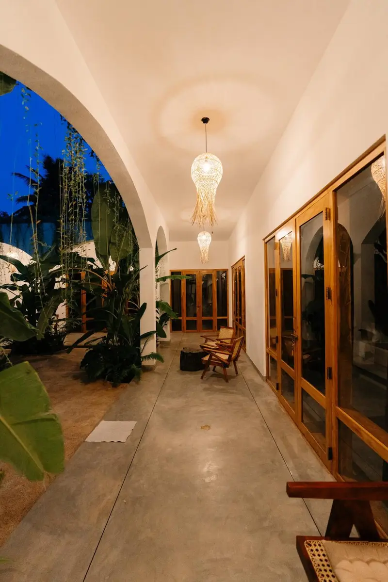 Arched corridor at blue hour with glowing lamps