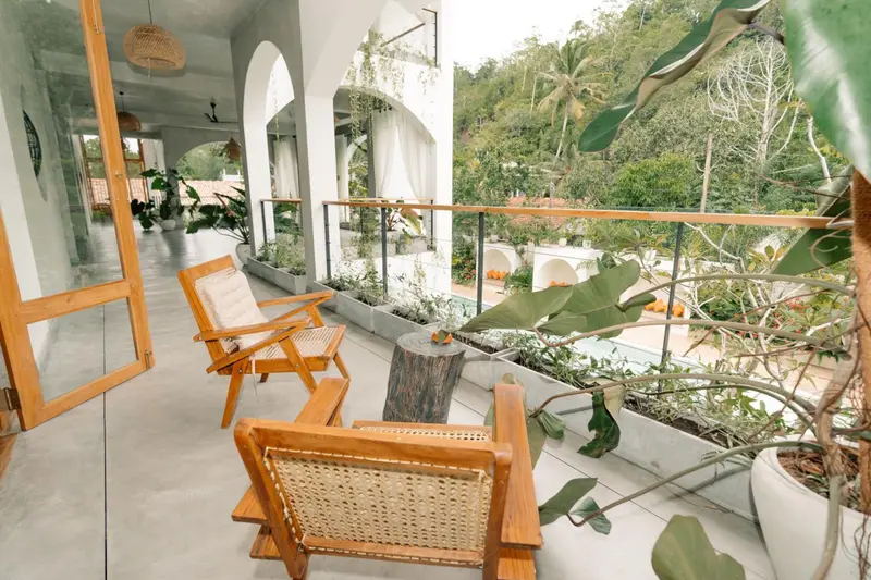 Shared upper balcony with cane chairs overlooking the jungle