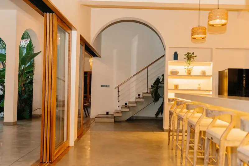 Breakfast bar beneath an arched doorway and open staircase