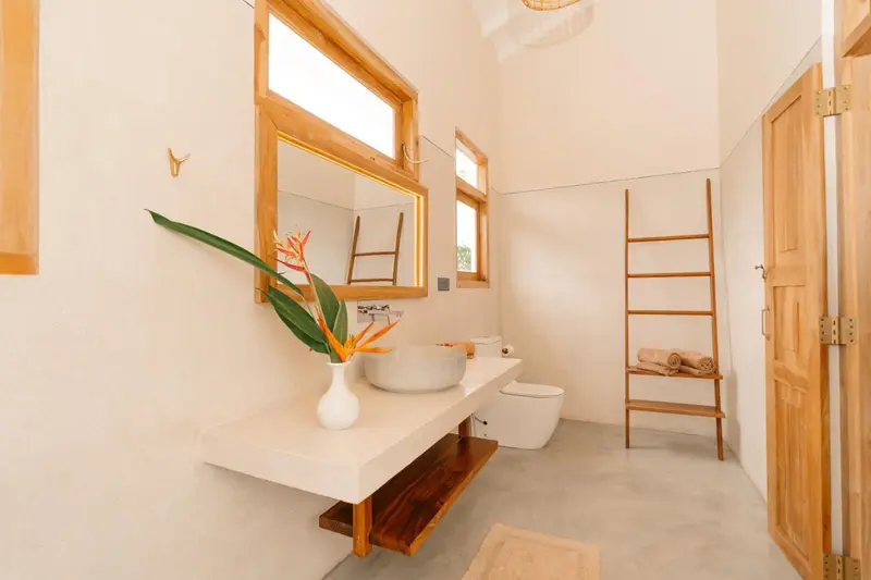 Bright bathroom with floating vanity and teak towel ladder