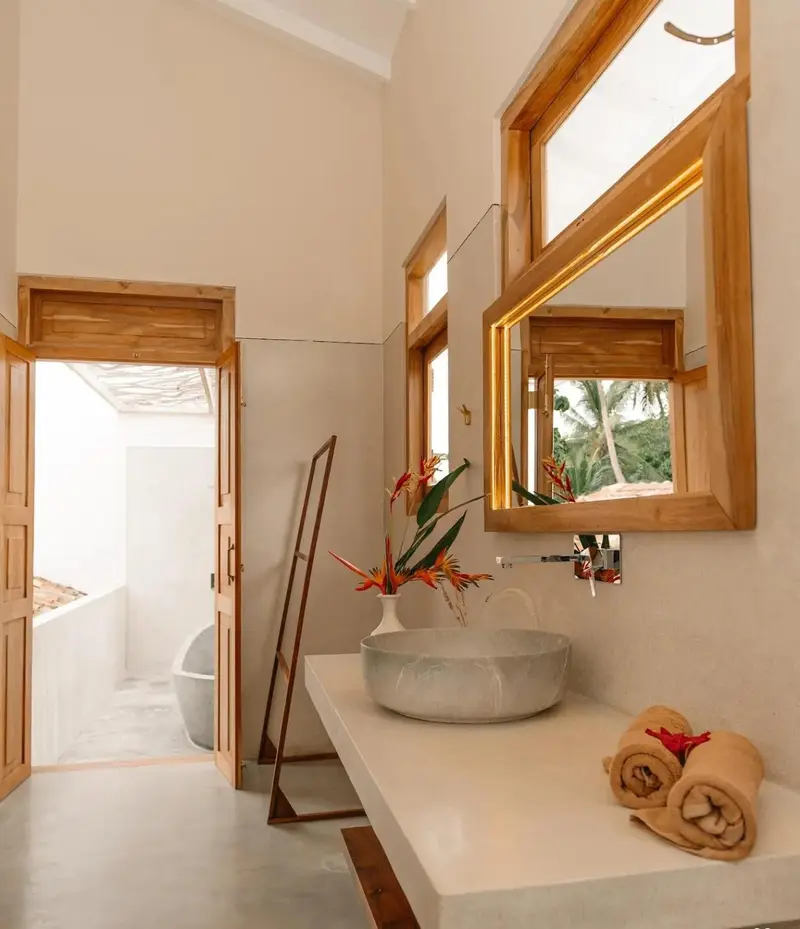 Stone vessel basin and teak-framed mirror in an en-suite
