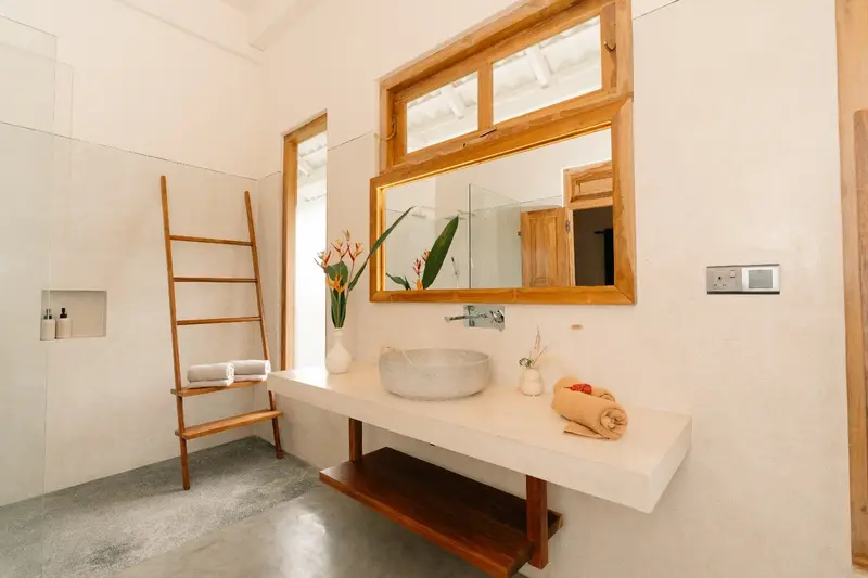 En-suite with stone basin, heliconia flowers, teak ladder and rain shower