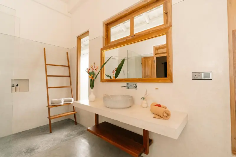 En-suite bathroom with stone basin, teak mirror and walk-in shower