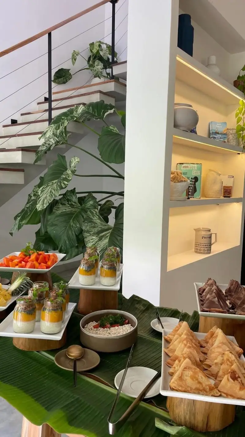 Breakfast buffet of fruit, pastries and parfaits on banana leaves