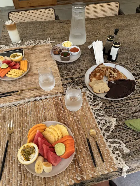 Breakfast of fruit, toast and eggs on a woven place mat