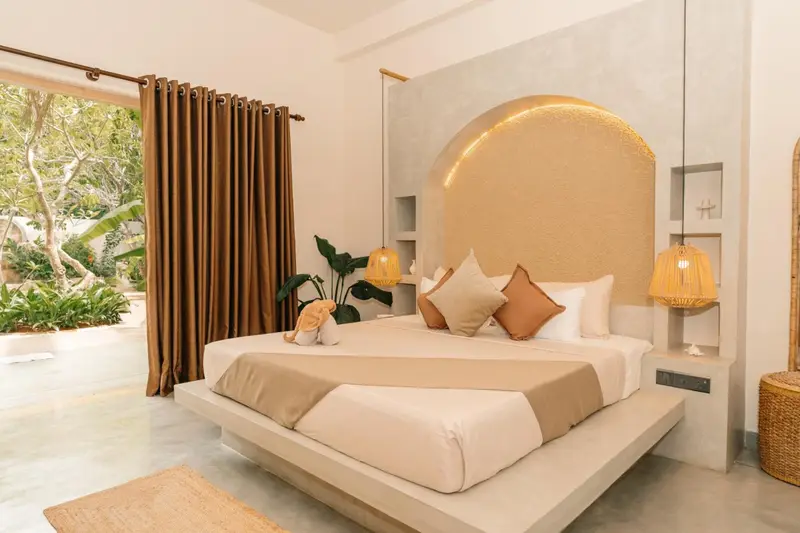 Deluxe Room with a king-size bed, arched gold headboard and garden doors