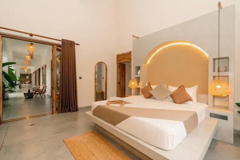 Deluxe Room with floating bed, rattan pendants and arched mirror