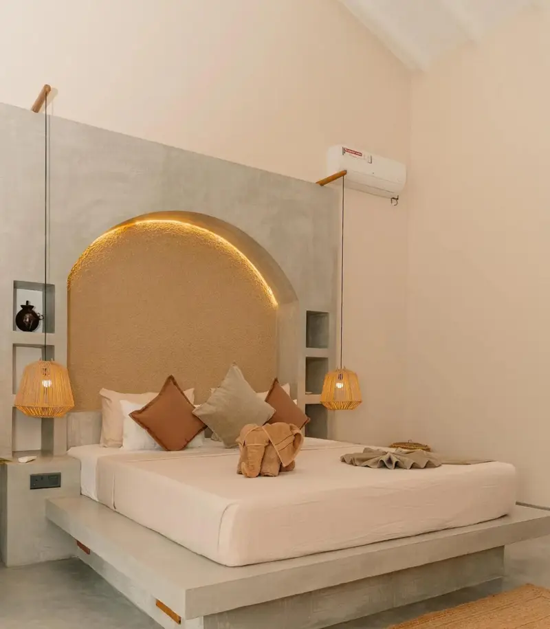 King-size bed with soft linen and woven pendant lights