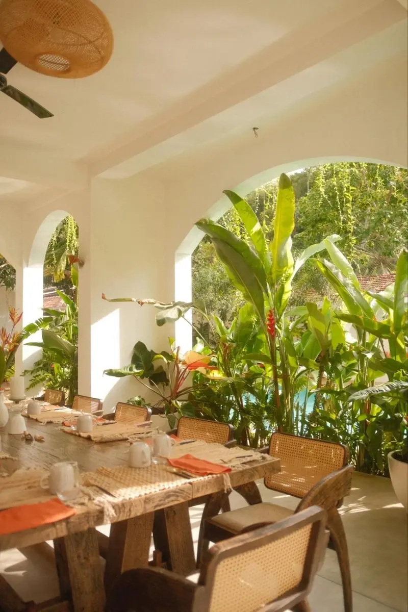 Dining terrace with arches opening onto banana plants