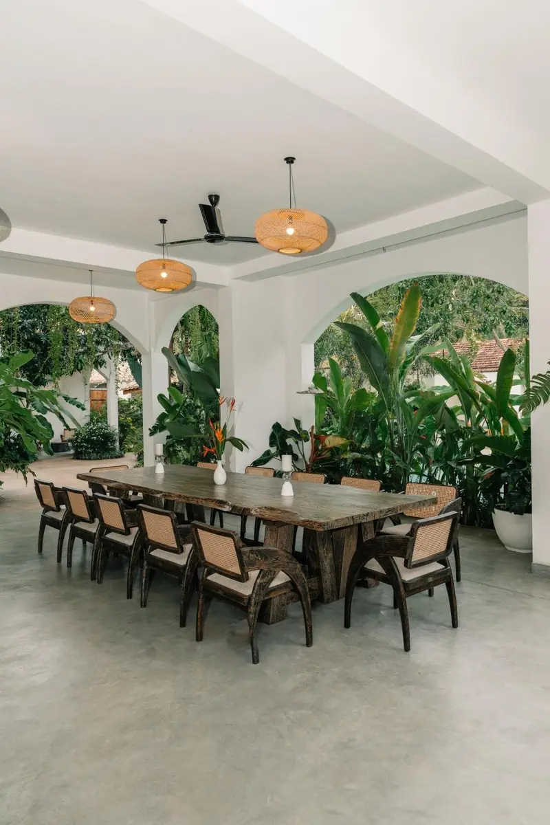 Dining table framed by arches and tropical plants