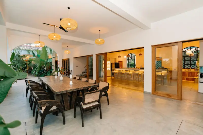 Communal dining table with the kitchen and bar beyond