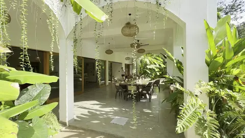 Dining hall seen through hanging vines and garden plants