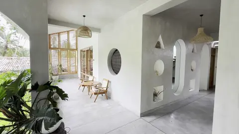 Arched veranda with porthole windows and cane chairs
