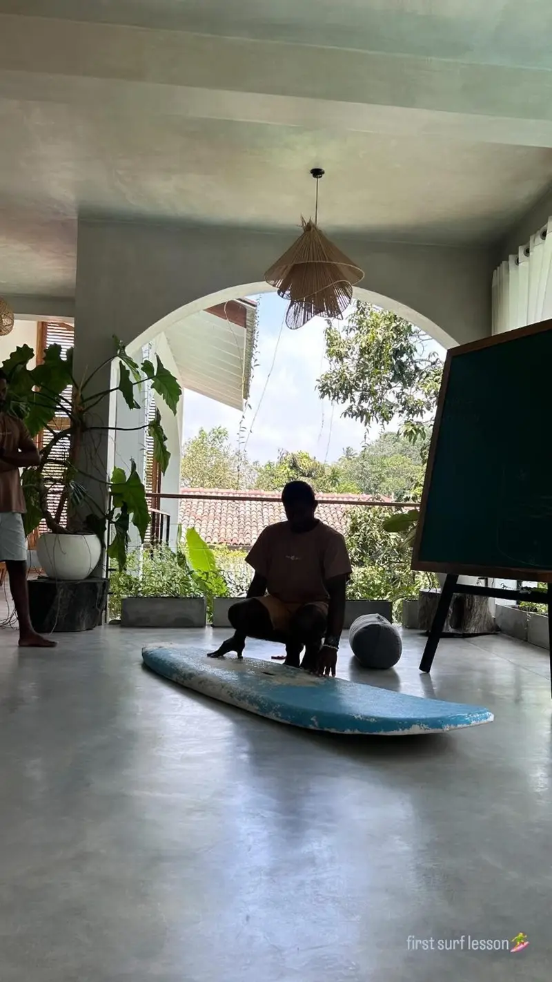 A guest with a surfboard in the shala
