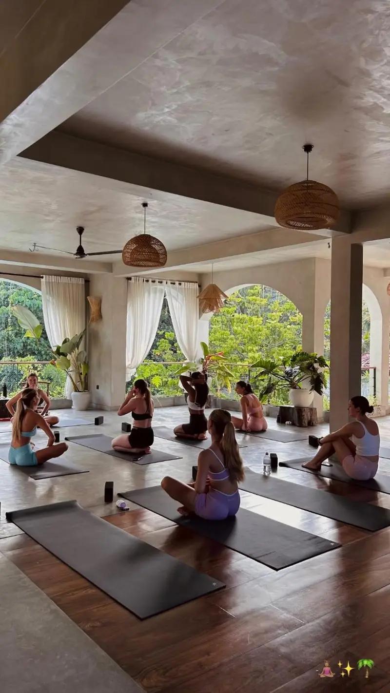 A yoga class in the open-sided shala