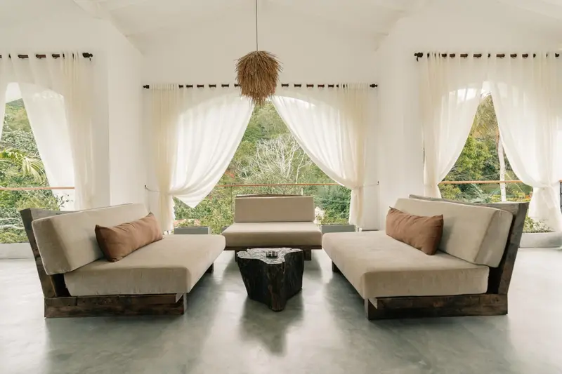 Breezy lounge with white curtains and jungle views