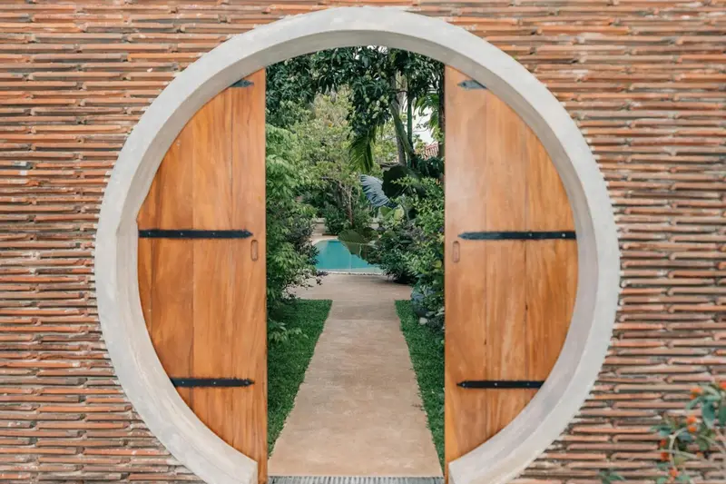 Round wooden moon gate opening onto the garden path