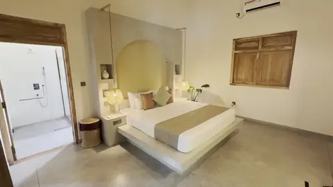 Room with king bed and en-suite shower beyond