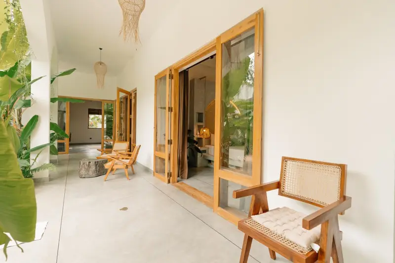 Room opening onto a private veranda with a cane armchair